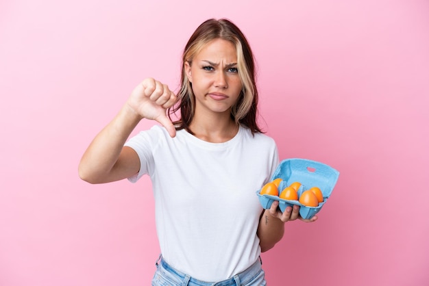 Banketbakker met muffins geïsoleerd op roze achtergrond glimlachend met een gelukkige en aangename uitdrukking