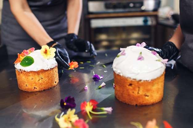 Banketbakker versiert paascake met delicate bloemen.