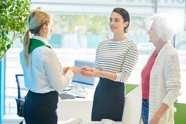 Photo banking customer specialist giving money to young lady with moth