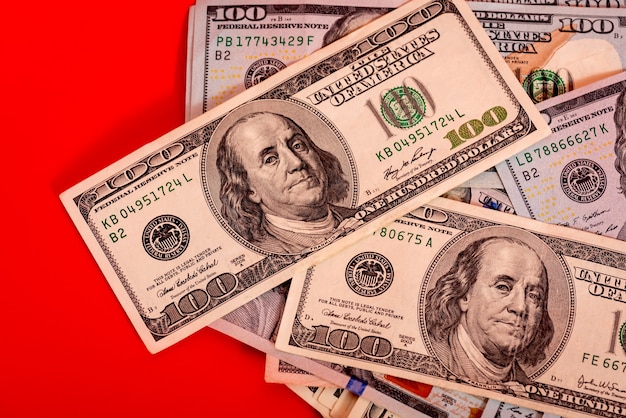 Банковское дело и финансовая концепция. Бумажные банкноты долларов на ярко-красном фоне.