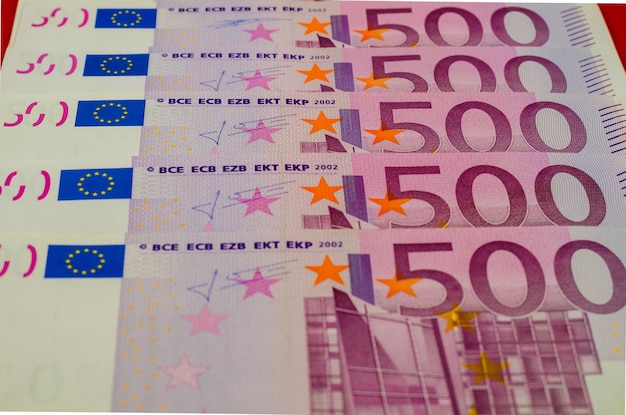 Банкноты в 500 евро лежат в ряд на столе.