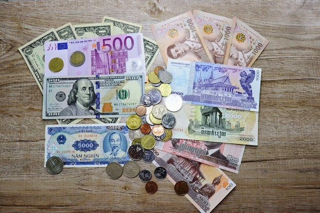Banknotes of different countries and colors on a wooden background