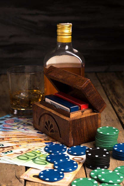 Banknotes next to poker chips and whiskey glass