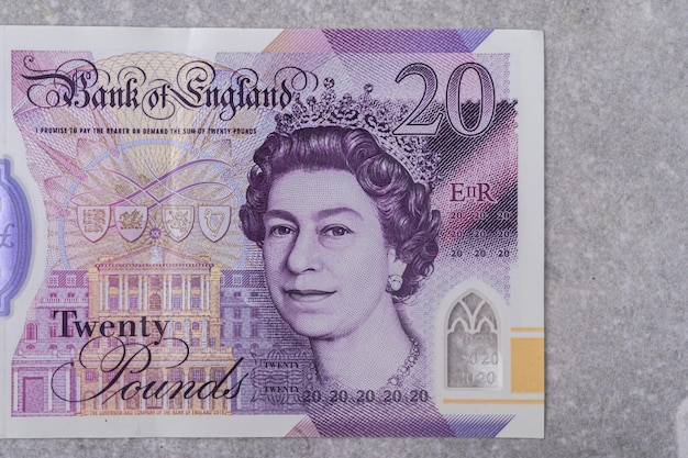 Banknotes with denomination and 20 images of Queen Elizabeth portrait on a gray background