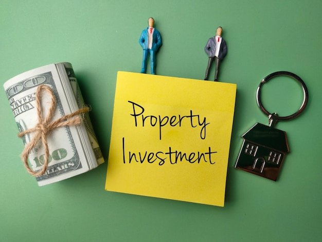 Banknotesminiature people and house keychain with the word Property Investment