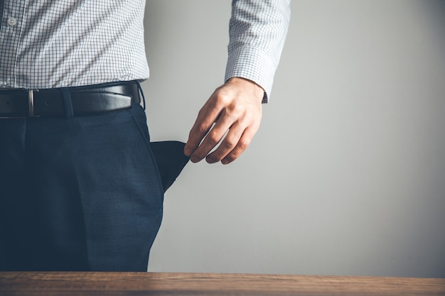 bankrupt business man showing empty pocket hand