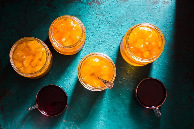 Banks with pineapple jam and tea on the table top view