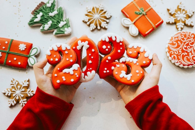 Banner for christmas and new year gingerbread cookies numbers 2023 on white background in child hands