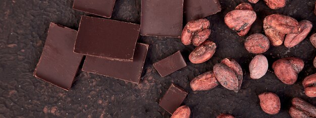 Banner of Cocoa beans background on brown table.