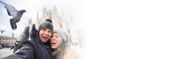 ミラノのドゥオーモ広場でハトとセルフ ポートレートを撮影するバナー カップル コピー スペース冬のイタリア旅行と関係の概念