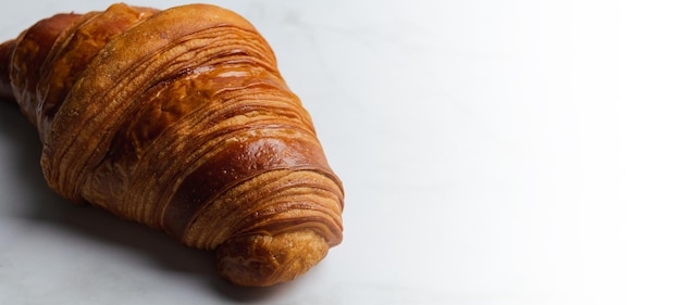 Banner di croissant isolato su sfondo di marmo.