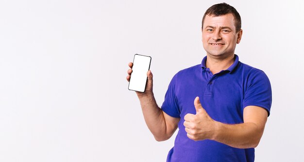 Banner. Deaf senior man shows thumb up while holding a mobile phone, white screen to the camera