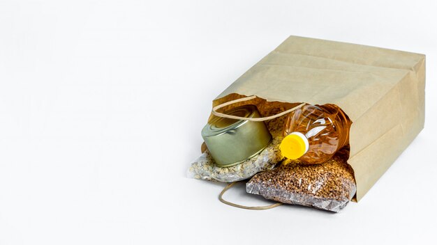 Banner. Food in a paper bag for donations, isolated on a white background. Anti-crisis stock of essential goods for period of quarantine isolation. Food delivery, coronavirus. shortage of food.