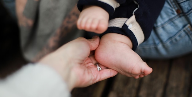 Banner The hand holds the baby is leg Leg of a newborn Kid on a walk