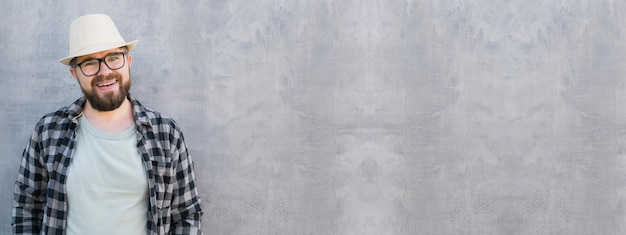 Banner handsome guy tourist looking happy wearing straw hat for travelling standing against concrete wall background with copy space