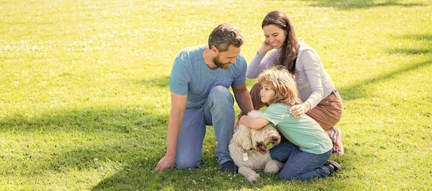 Banner of Happy family Lying on grass Young mother and father with child son play with dog in the park resting together on the green grass Family with pet