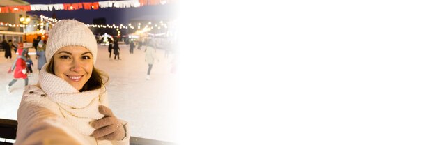 배너 스마트폰 셀카 복사 공간에서 사진을 찍는 아이스 링크에서 겨울에 행복 한 젊은 여자