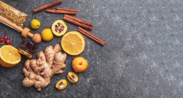 Photo banner of healthy ingredients lemon cinnamon ginger cydonia honey berries chamomile flowers propolis to prevent cold health and diet concept