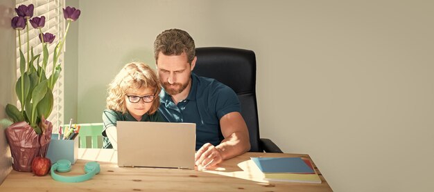 Banner of home school of father and son with laptop at home concentrated father and son in glasses