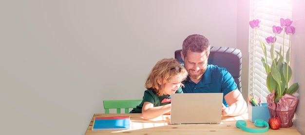 Banner of home school of father and son with laptop at home\
happy mature man teacher or dad helping