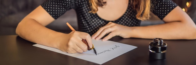 Banner lang formaat goedemorgen kalligraaf jonge vrouw schrijft zin op wit papier inscriptie