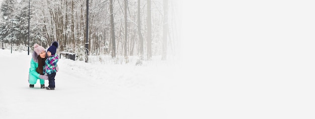 Banner little girl and her mom having fun on a winter day copy space