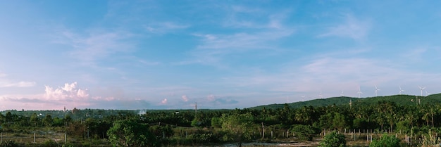 Banner formato lungo ritaglialo panorama paesaggio estivo nuvole tempio buddista statua mulini a vento cielo blu meditazione sfondo