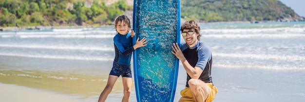 BANNER LONG FORMAT Father or instructor teaching his son how to surf in the sea on vacation or holiday Travel and sports with children concept Surfing lesson for kids