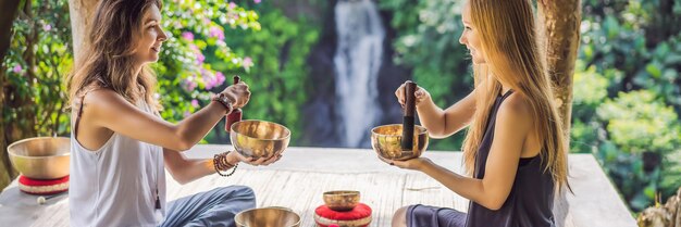 Banner long format nepal buddha copper singing bowl at spa salon young beautiful woman doing massage