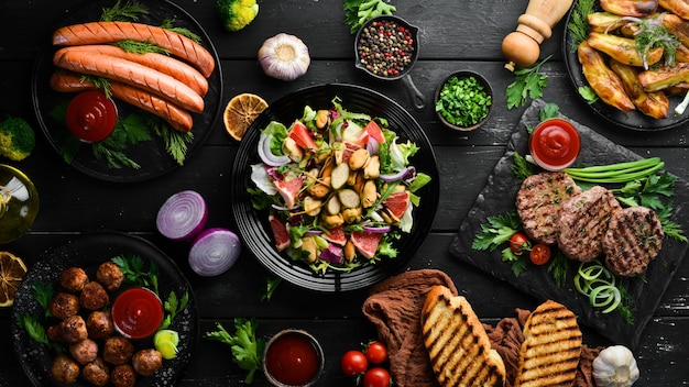 Photo banner meat and vegetable dishes and snacks on black background top view free space for your text