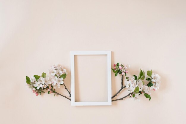 Banner met een bloem en een leeg wit frame voor foto's op een beige achtergrond met kopieerruimte