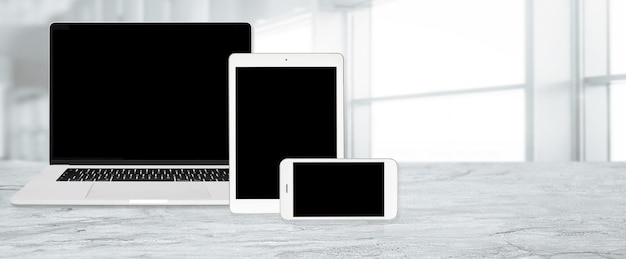 Foto banner di tecnologia multi-dispositivo per tablet e smartphone digitali per laptop con design web reattivo in vari orientamenti nello spazio di copia dell'ufficio