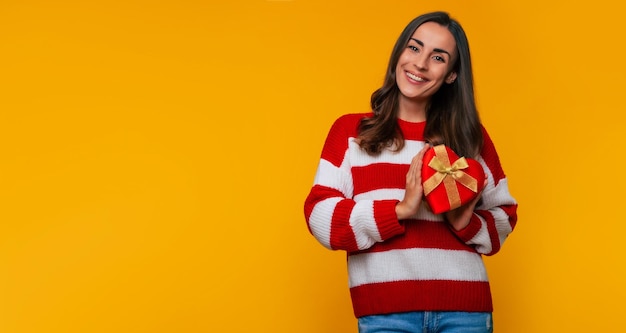 Banner photo of gorgeous happy brunette woman with gift box in the shape of a heart in hands from her beloved in some holiday