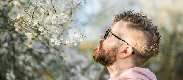 写真 春の花の香りを吸い込んでいる 曲がりくねった千年の男のバナー肖像画