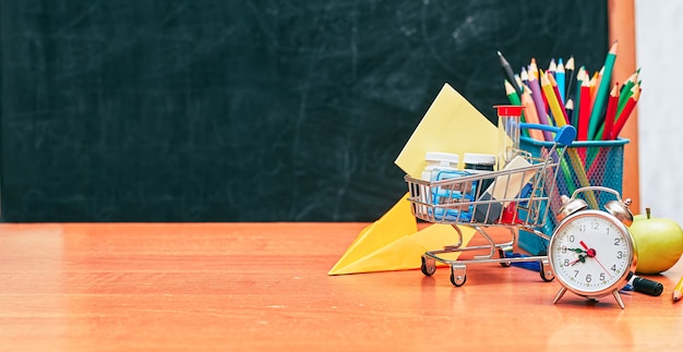 Photo banner school still life shopping cart with stationery on school board background university college