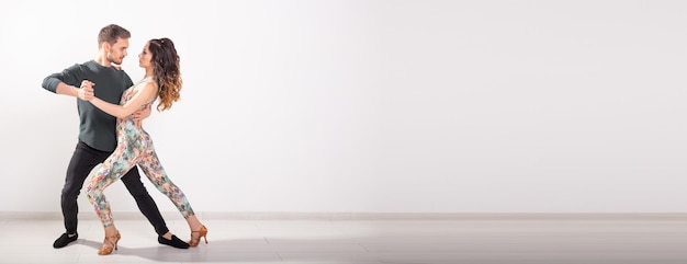 Баннер социальный танец бачата сальса кизомба зук танго концепция мужчина обнимает женщину во время танца на белом фоне с копировальным пространством