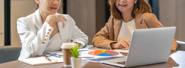 Banner, web page or cover template of two asian businesswomen working with the partner business via technology laptop in modern meeting room, office or working space, partner and colleague concept