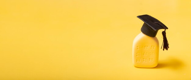 Foto banner con cappello da laureato sull'edificio astratto concetto di istituto di istruzione sfondo giallo con spazio per la copia