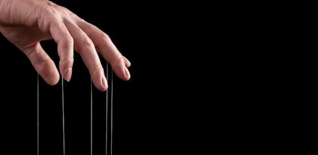 Banner with man hand with strings on fingers Manipulation or addiction concept Master abuser using influence to control person behavior Copy space