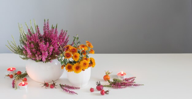 Banner with yellow flowers with burning candles on gray background