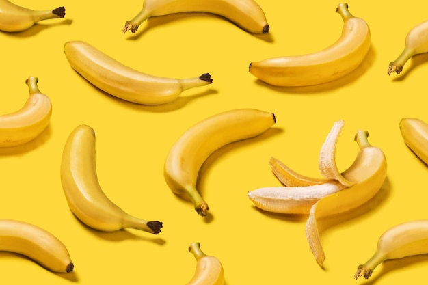 Foto bannerbananen met harde schaduwen creatief patroon op gele achtergrond plat gelegd