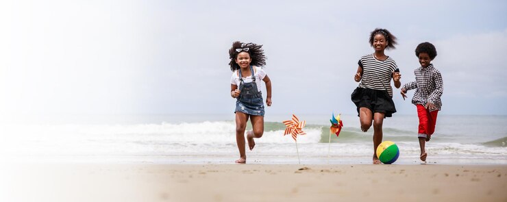 Bannergrootte Groep gelukkige Afro-Amerikaanse kinderen die op een tropisch strand rennen