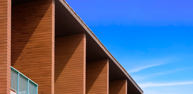 Bannister met kunstmatige houten schaduwvinnen van moderne rijtjeshuizen tegen blauwe lucht in panoramisch zicht