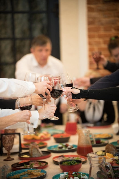 Банкетный стол в ресторане Люди в официальной одежде Чокают бокалы вина в фокусе