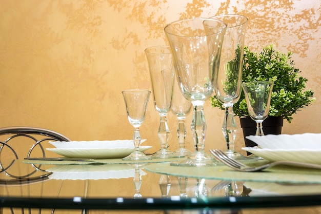 Banquet table served with instruments and decorated with empty wine glasses