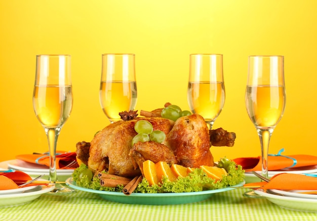 Banquet table with roast chicken on orange background closeup Thanksgiving Day