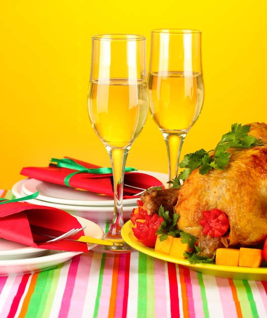 Banquet table with roast chicken on orange background closeup thanksgiving day