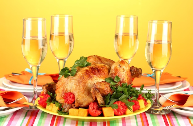 Banquet table with roast chicken on orange background closeup thanksgiving day