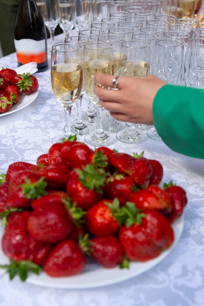 A banquet table with wine glasses and plates with strawberries