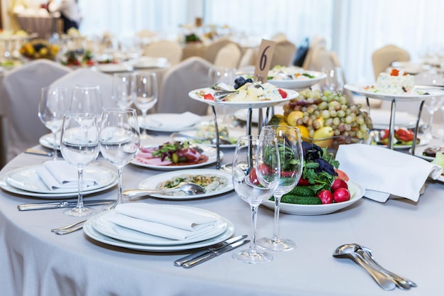 banquet table without people served with food and eating utensils forks spoons glasses